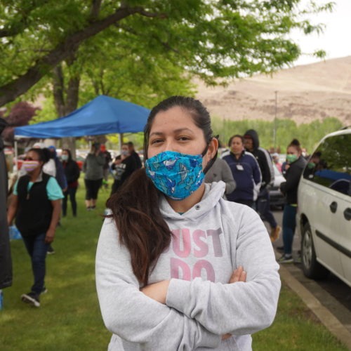 Perla Torres, a fruit packer at Jack Frost Fruit, poses for a photograph wearing a mask she says she bought from a supervisor. CREDIT: Enrique Pérez de la Rosa/NWPB