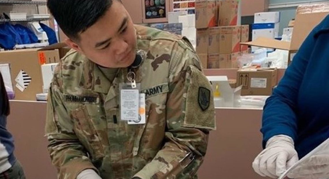 A Washington Army National Guard soldier consults instructions while assembling a Covid-19 test kit at a state warehouse in Tumwater. The National Guard is currently helping to assemble 30,000 kits for distribution to local public health agencies.