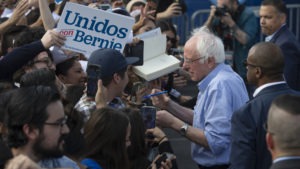 Sen. Bernie Sanders signs autographs at a February campaign event with Latino supporters in Santa Ana, Calif. Some Democrats say the Biden campaign can learn from Sanders' outreach. 