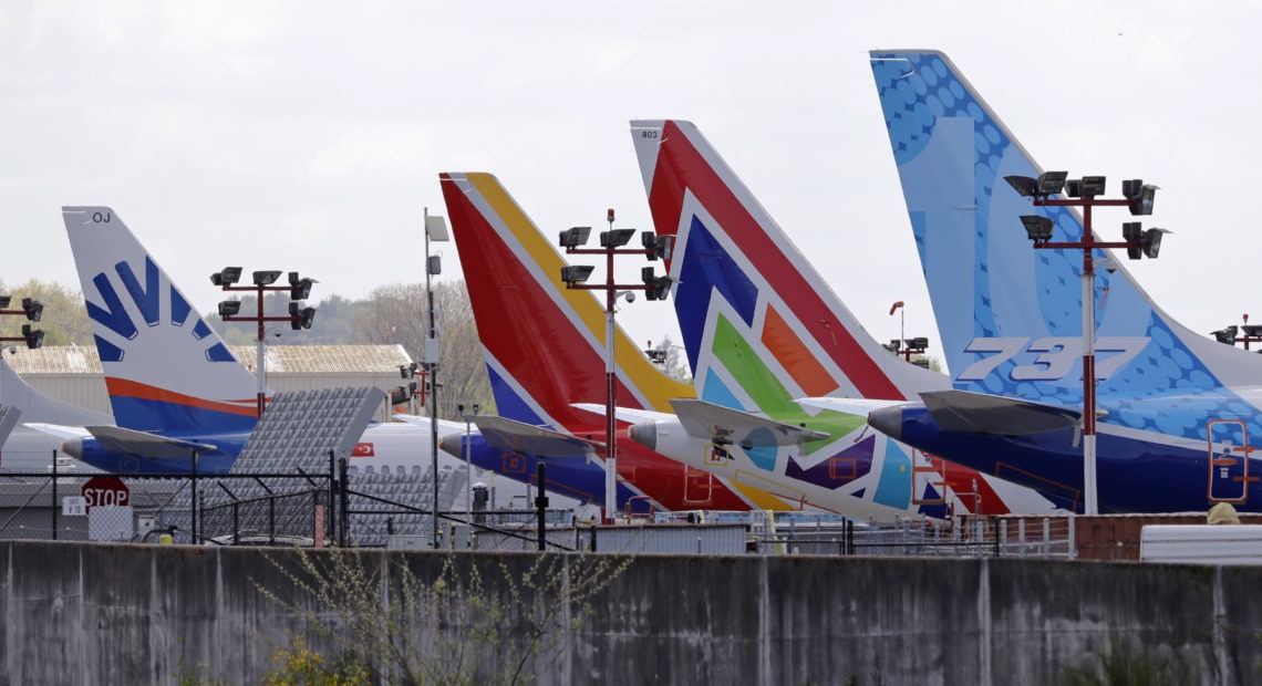 A line of Boeing 737 MAX jets sit parked on the airfield adjacent to a Boeing production plant last month in Renton, Wash. Boeing now says it is cutting thousands of jobs