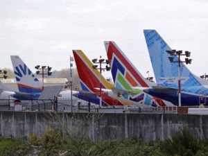 A line of Boeing 737 MAX jets sit parked on the airfield adjacent to a Boeing production plant last month in Renton, Wash. Boeing now says it is cutting thousands of jobs