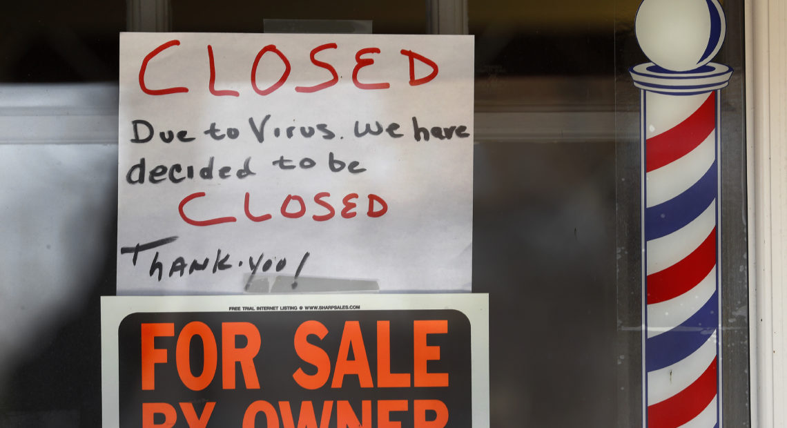 Signs are displayed in the window of a store in Grosse Pointe Woods, Mich.