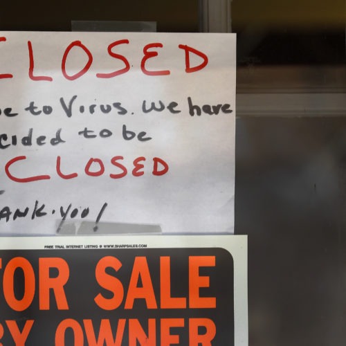Signs are displayed in the window of a store in Grosse Pointe Woods, Mich.