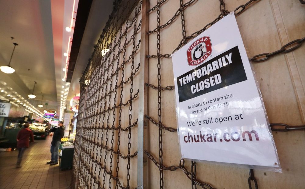 A sign explains the closure of a shop in the Pike Place Market in Seattle. As the coronavirus outbreak has caused record number of people to seek unemployment benefits Washington state officials said Thursday that impostors have used the stolen information of tens of thousands of people to receive hundreds of millions of dollars in unemployment benefits.