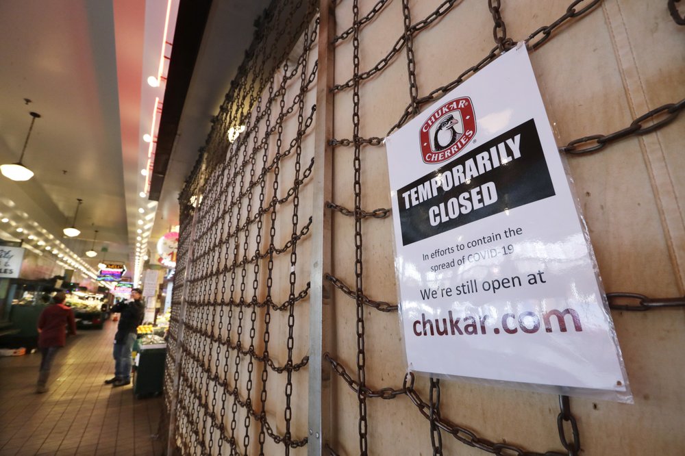 A sign explains the closure of a shop in the Pike Place Market in Seattle. As the coronavirus outbreak has caused record number of people to seek unemployment benefits Washington state officials said Thursday that impostors have used the stolen information of tens of thousands of people to receive hundreds of millions of dollars in unemployment benefits.