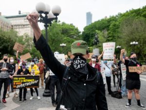 A protester raises a fist during a "Black Lives Matter" demonstration Thursday in New York City — just one of a number of protests nationwide inspired by Floyd's death in Minneapolis.