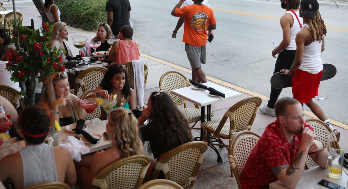 As late as March 17, people eat at a restaurant along Ocean Drive in Miami Beach, Fla., several days after President Trump declared a national emergency.