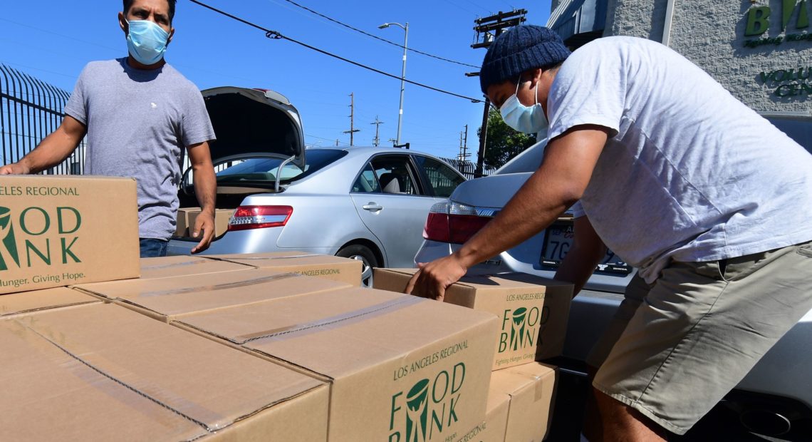 People load their vehicles with boxes of food at a Los Angeles Regional Food Bank earlier this month in Los Angeles. Food banks across the United States are seeing numbers and people they have never seen before amid unprecedented unemployment from the COVID-19 outbreak.