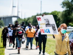 People return to their vehicles after gathering to honor the life of Ahmaud Arbery at Sidney Lanier Park on May 9 in Brunswick, Ga. Arbery was shot and killed while jogging in the nearby Satilla Shores neighborhood on Feb. 23.