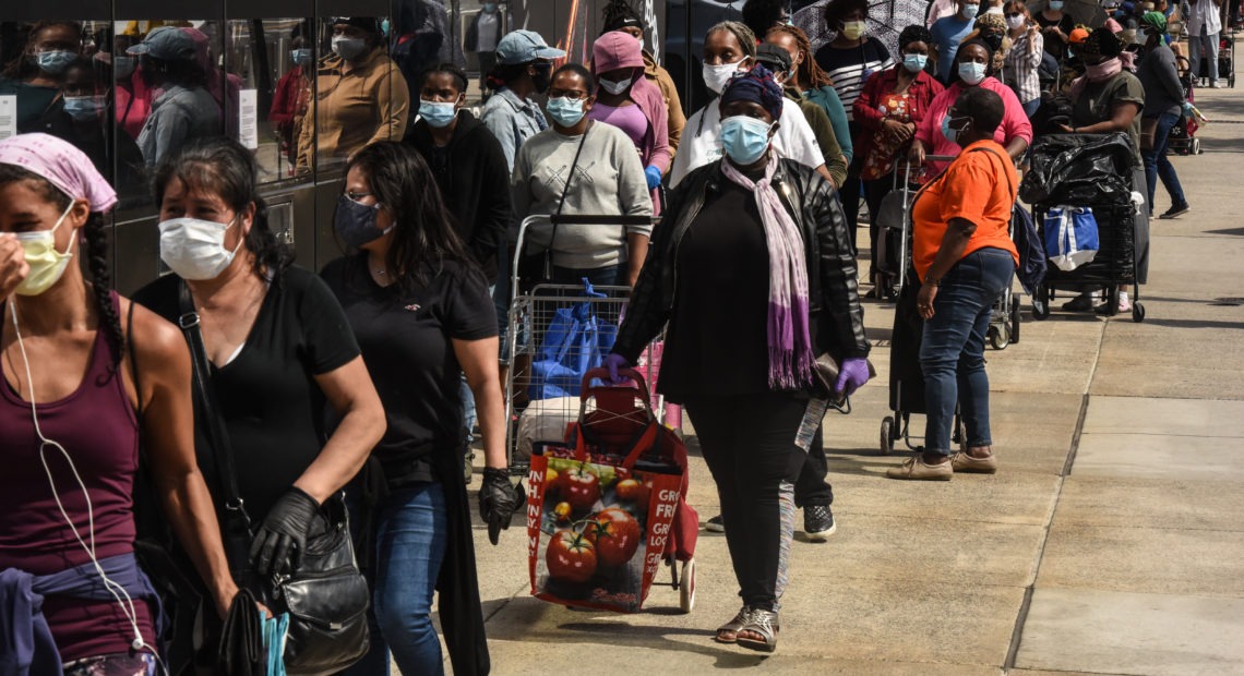 People wait in a long line to receive a food bank donation at the Barclays Center on May 15 in Brooklyn, N.Y. Across the country, cities and towns are dealing with the highest unemployment rates since the Great Depression.