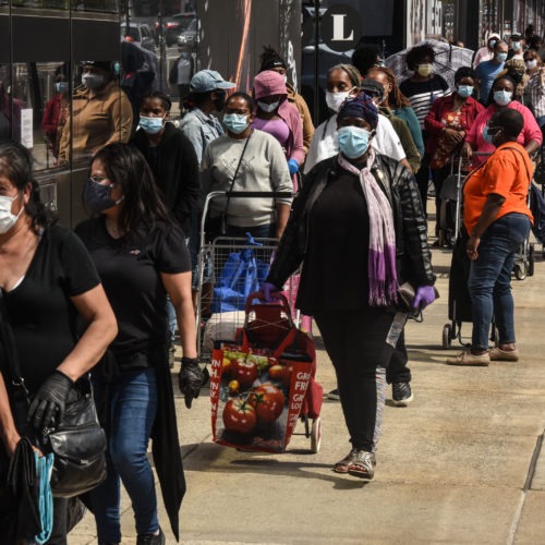 People wait in a long line to receive a food bank donation at the Barclays Center on May 15 in Brooklyn, N.Y. Across the country, cities and towns are dealing with the highest unemployment rates since the Great Depression.