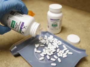 A pharmacy tech pours out pills of hydroxychloroquine May 20 at Rock Canyon Pharmacy in Provo, Utah, on May 20, 2020. After a study found COVID-19 patients using the drug were dying at higher rates, the World Health Organization announced it would suspend its clinical trial. CREDIT: George Frey/AFP via Getty Images