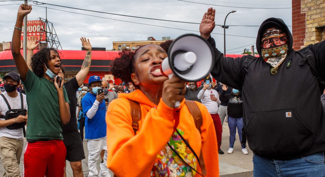 A woman leads a group of protesters in chants outside a police precinct on Wednesday in Minneapolis. The death of George Floyd, after video surfaced of an officer kneeling on his neck, has prompted protests nationwide.