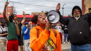 A woman leads a group of protesters in chants outside a police precinct on Wednesday in Minneapolis. The death of George Floyd, after video surfaced of an officer kneeling on his neck, has prompted protests nationwide.