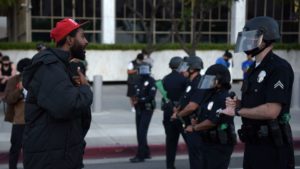 A demonstrator explains himself to an officer in riot gear during a protest Wednesday in downtown Los Angeles. The impact of Floyd's death has been felt well beyond Minneapolis' city limits.