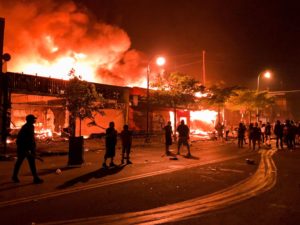 Flames rise from a liquor store and shops near the 3rd Police Precinct in Minneapolis on Thursday , during a protest over the death of George Floyd.