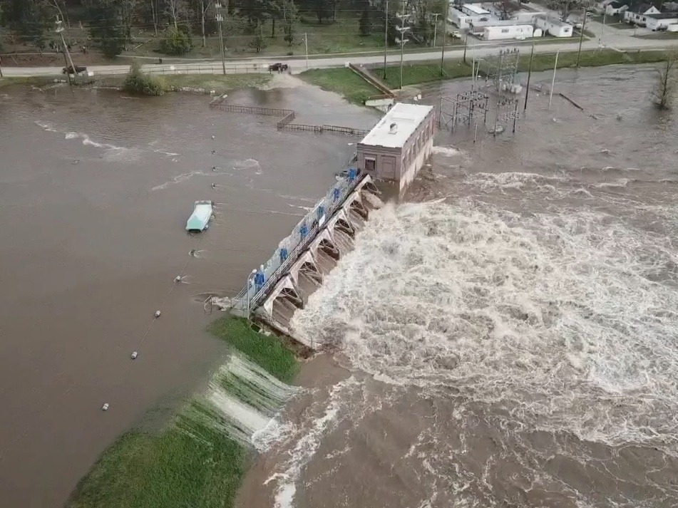 Water overruns the Sanford Dam in Michigan on Tuesday. The National Weather Service called the flooding "extremely dangerous" and said it was caused by "catastrophic failures" at two dams. CREDIT: TC Vortex via Reuters