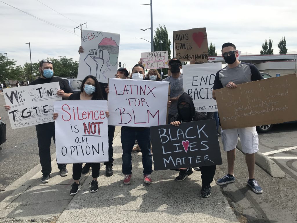 Jordan Chaney (carrying the black sign) stands with a group of protesters in Pasco. “Justice is equality. Justice is what love looks like in public,” he says.