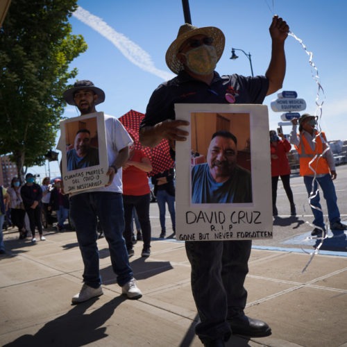 Farmworkers in Yakima’s fruit-packing industry walked off production lines in May and went on strike, demanding more protections against the coronavirus pandemic. Above, Emmanuel Anguiano-Mendoza (left) and Agustin López hold posters featuring David Cruz, a worker who died on May 30. CREDIT: Enrique Pérez de la Rosa/NWPB