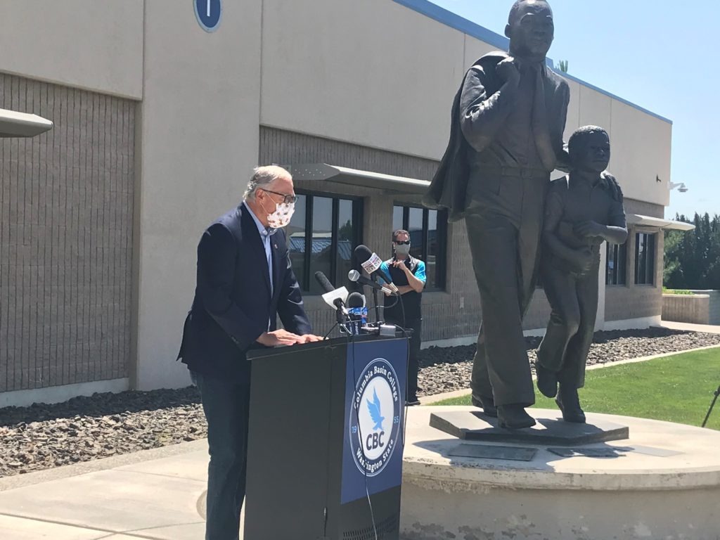 Washington Gov. Jay Inslee speaks at a news conference at Columbia Basin College in Pasco June 30, 2020. Hecklers yelling at him, some with signs and flags for Trump 2020 and Republican gubernatorial candidate Loren Culp, caused the event to be moved inside. CREDIT: Courtney Flatt/NWPB