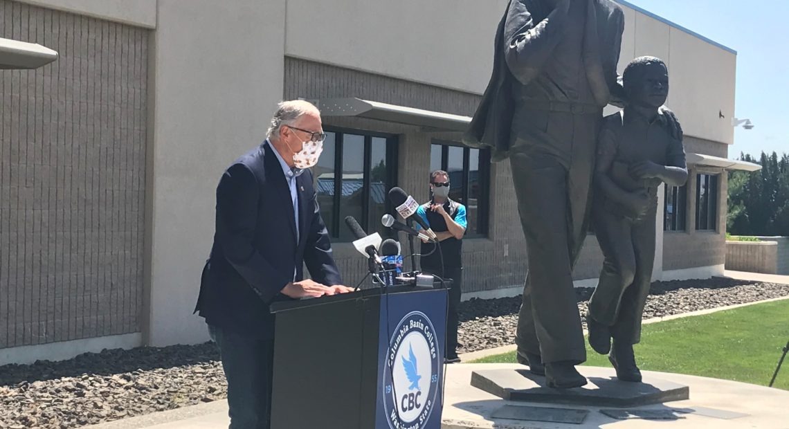Washington Gov. Jay Inslee speaks at a news conference at Columbia Basin College in Pasco June 30, 2020. Hecklers yelling at him, some with signs and flags for Trump 2020 and Republican gubernatorial candidate Loren Culp, caused the event to be moved inside. CREDIT: Courtney Flatt/NWPB