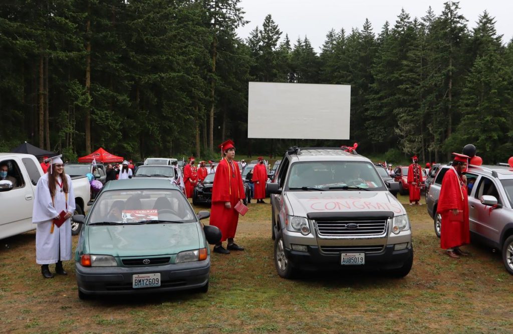 Port Townsend High School seniors looked to a temporary stage near the back of the drive-in theater, rather than toward the big screen, during their graduation on June 12, 2020. CREDIT: Tom Banse/N3