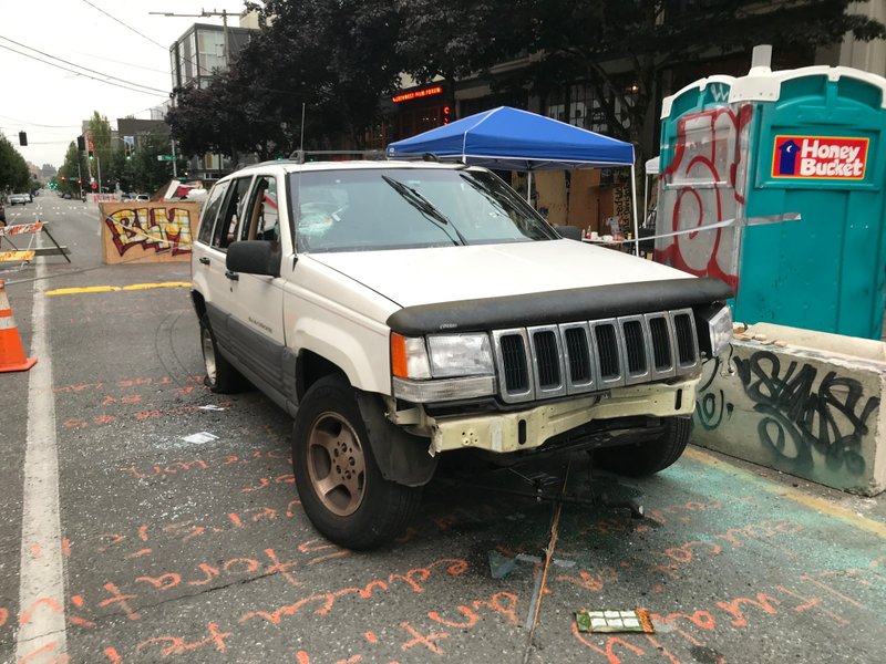 A Jeep Cherokee sits in the Capitol Hill Organized Protest zone following a shooting in Seattle early June 29, 2020. At least one man was killed and another was wounded early Monday morning when they were shot in the protest area known as CHOP, after driving the vehicle into the area. CREDIT: Aron Ranen/AP