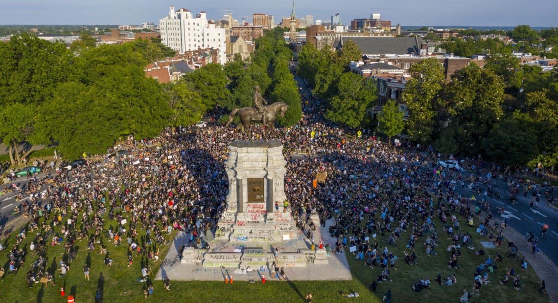 A large group of protesters gathered around the statue of Confederate Gen. Robert E. Lee, on Tuesday in Richmond, Va. The crowd protesting police brutality chanted, "Tear it down."