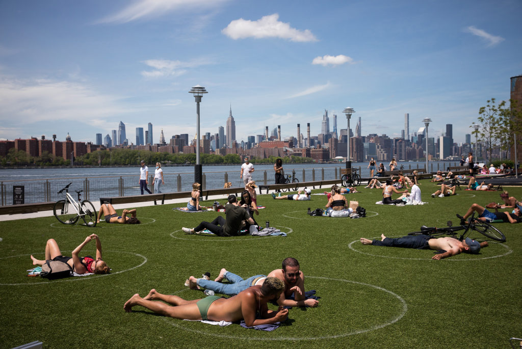 People rest inside social distancing markers at Domino Park in the Brooklyn borough of New York in late May. Stay-at-home orders in New York helped to lower the state's "reproduction number," which estimates how many people one sick person could infect with the coronavirus. CREDIT: Michael Nagle/Xinhua News Agency/Getty Images