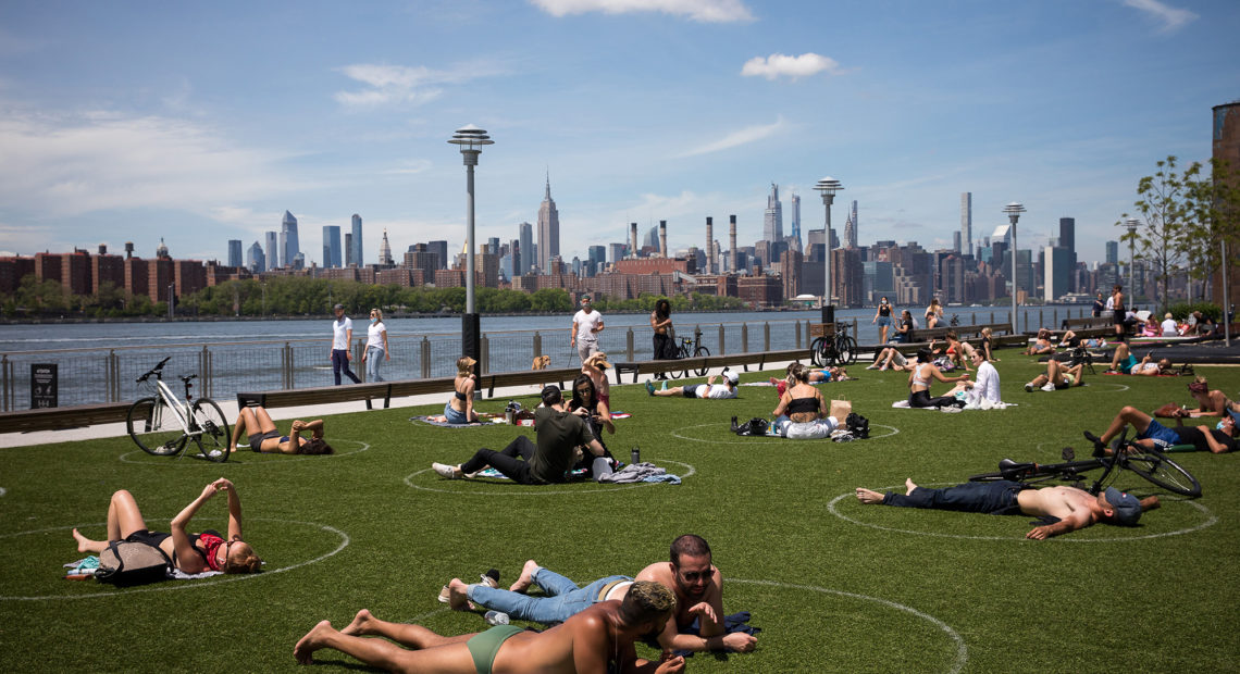 People rest inside social distancing markers at Domino Park in the Brooklyn borough of New York in late May. Stay-at-home orders in New York helped to lower the state's "reproduction number," which estimates how many people one sick person could infect with the coronavirus. CREDIT: Michael Nagle/Xinhua News Agency/Getty Images