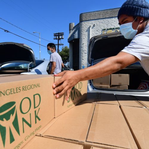 Boxes of food are loaded on vehicles last month at the Los Angeles Regional Food Bank. The country has officially entered a recession amid the pandemic, the National Bureau of Economic Research said Monday. CREDIT: Frederic J. Brown/AFP via Getty Images