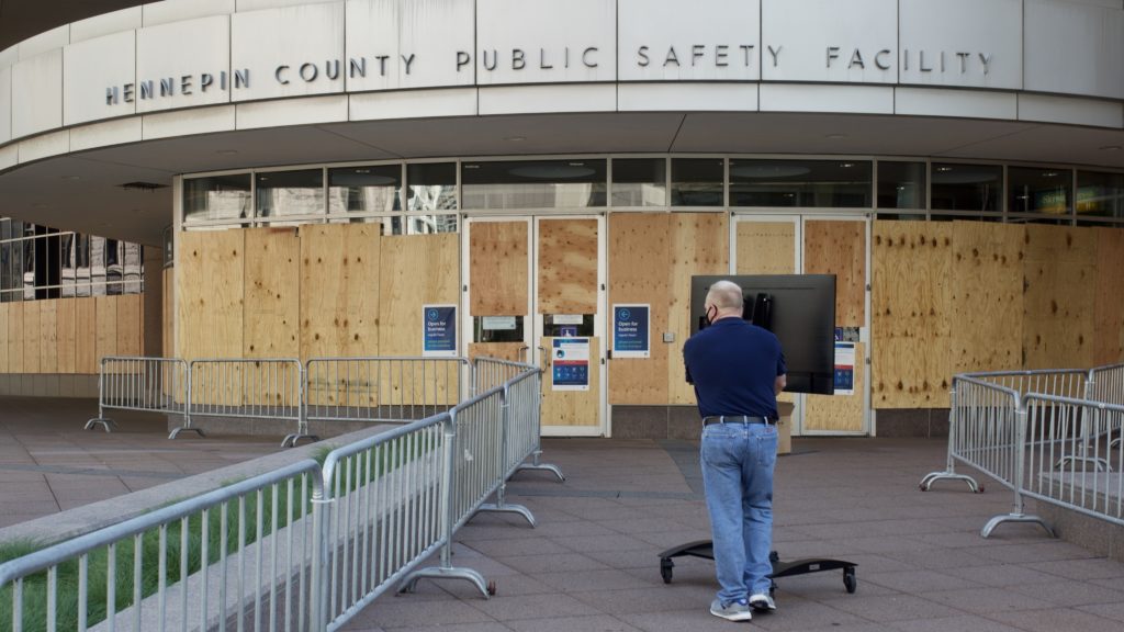 A facility worker brings a TV inside the Hennepin County Public Safety Facility on Monday in Minneapolis, part of preparations for the first court hearing for former police Officer Derek Chauvin. Kerem Yucel /AFP via Getty Images