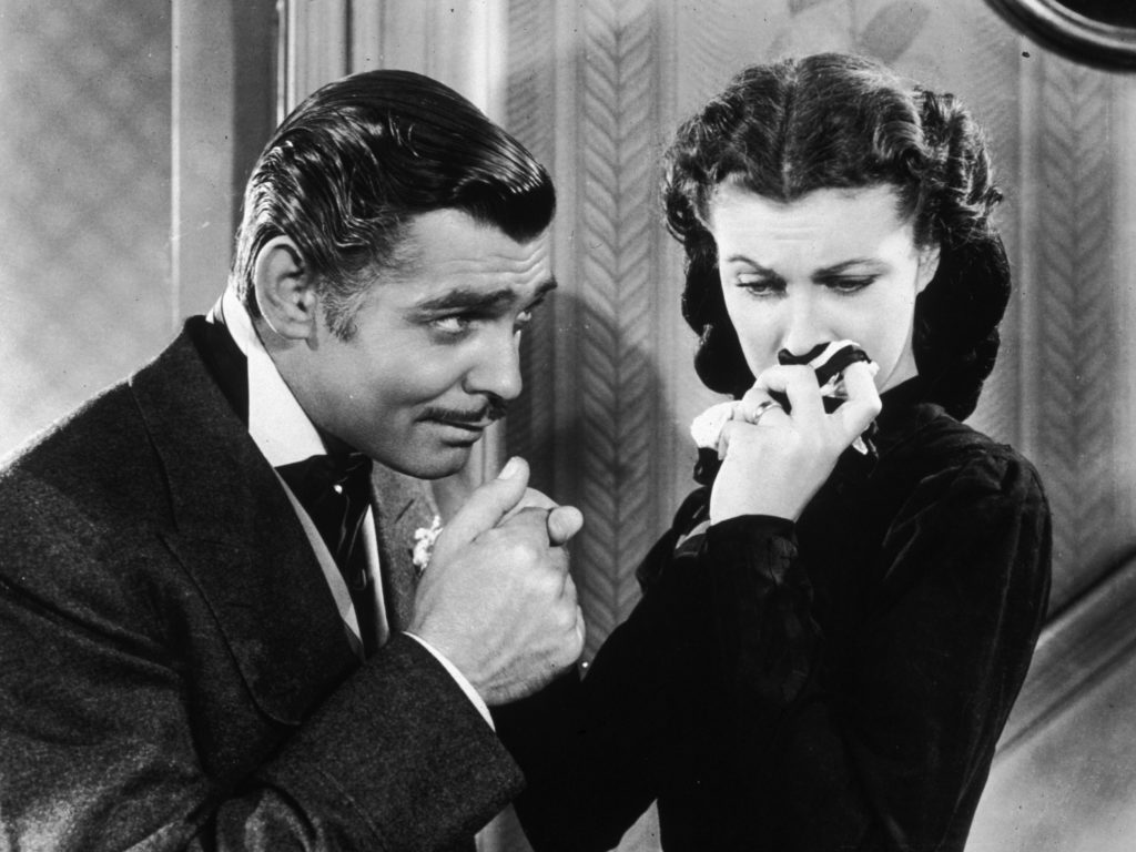 American actor Clark Gable in his role as Rhett Butler kissing the hand of a tearful Scarlett O'Hara, played by Vivien Leigh in 'Gone With The Wind'.
