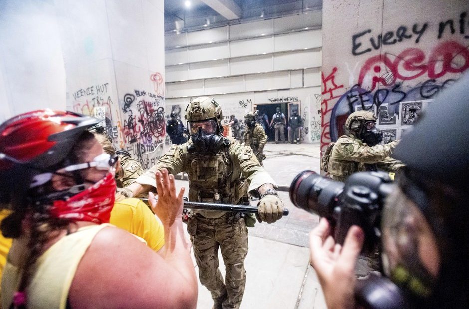 A federal officer pushes back demonstrators at the Mark O. Hatfield United States Courthouse on Tuesday, July 21, 2020, in Portland. CREDIT: Noah Berger/AP