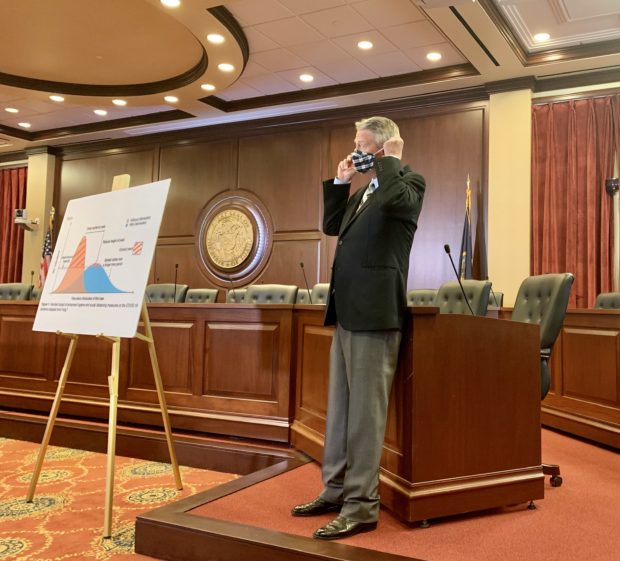 Gov. Brad Little adjusts his mask during a July 9 press conference at the Statehouse.
