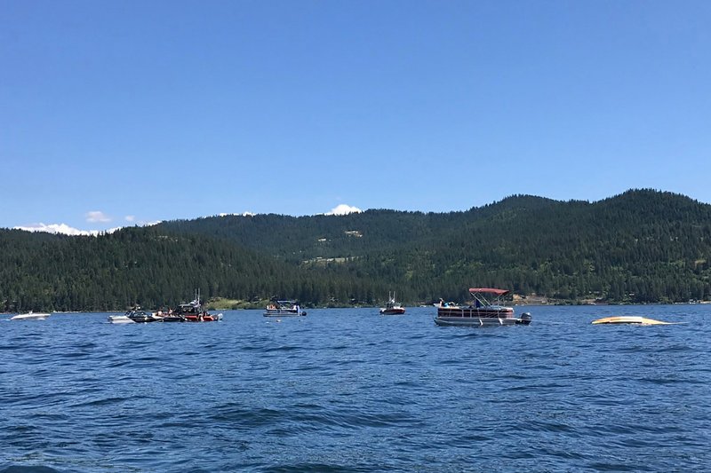 Boaters flag down authorities to a crashed seaplane near Powderhorn Bay on Lake Coeur d'Alene on Sunday, July 5, 2020. One downed plane can be seen in the right side of the image. CREDIT: Stephanie Hammett/The Spokesman-Review via AP