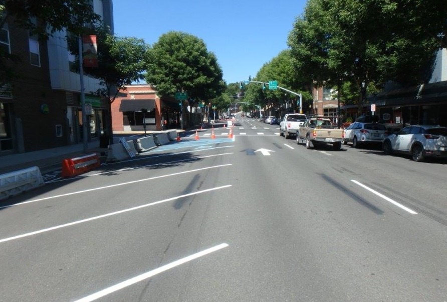 Pullman's downtown one-way traffic was previously three lanes. A recent test added angle parking and a protected bike lane to study traffic flow and pedestrian use. CREDIT: WSDOT