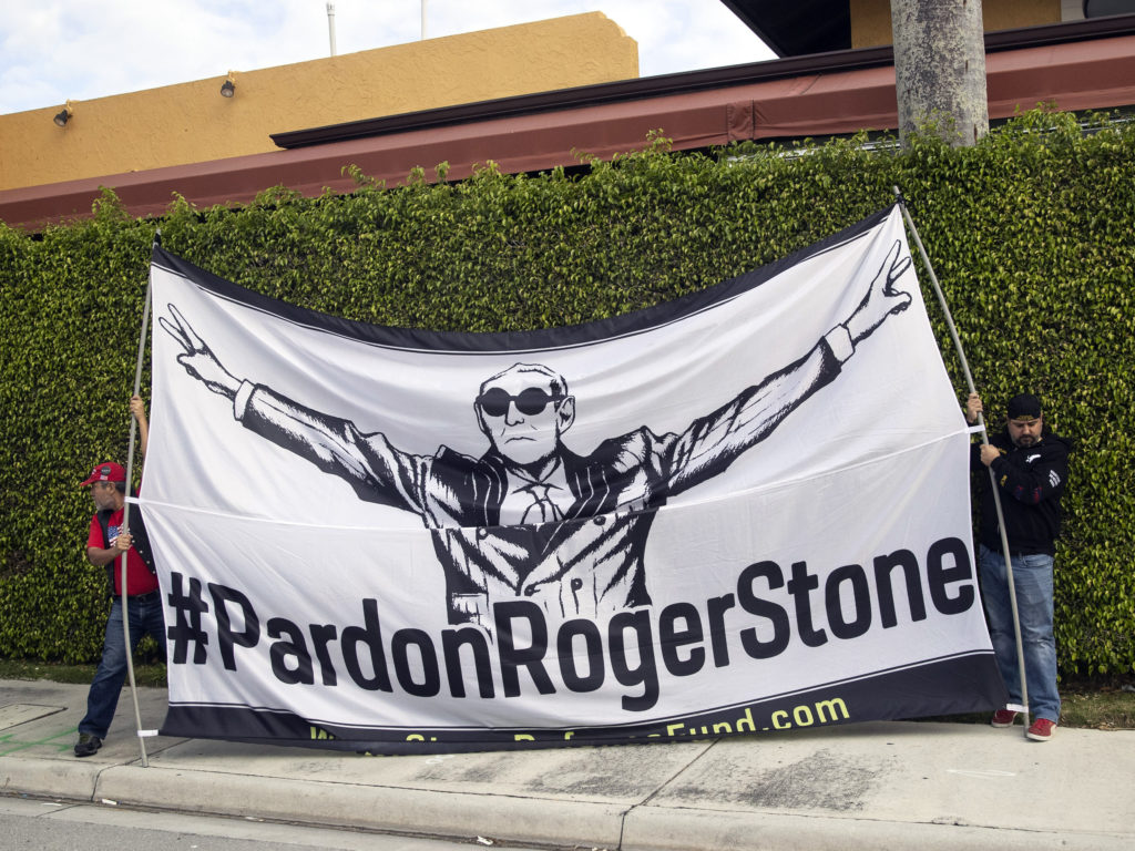 Activists display a sign in support of Stone as President Trump's motorcade heads to Palm Beach International Airport in March in West Palm Beach, Fla. Alex Brandon/AP