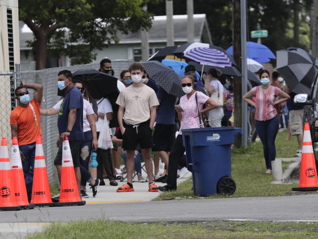 People wait in line outside a testing site in Florida. The state has seen unprecedented surges in coronavirus cases in recent weeks. CREDIT: Lynne Sladky/AP