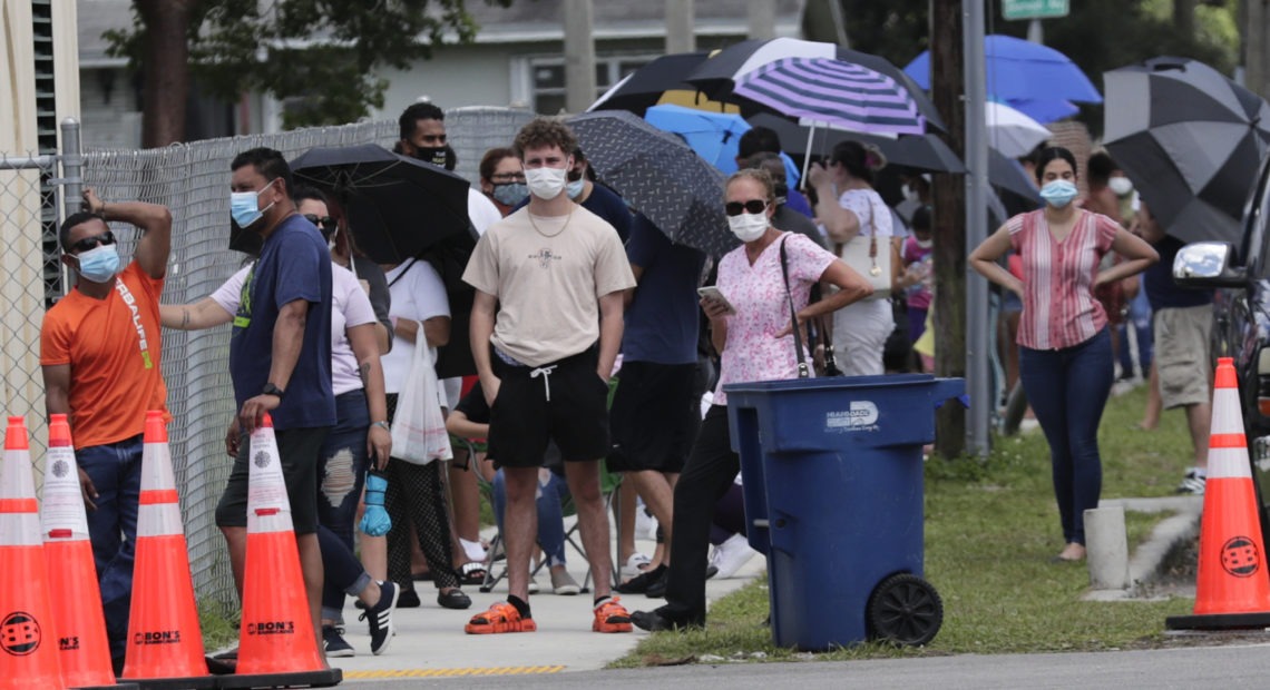 People wait in line outside a testing site in Florida. The state has seen unprecedented surges in coronavirus cases in recent weeks. CREDIT: Lynne Sladky/AP