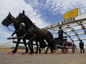 The casket of Rep. John Lewis crosses the Edmund Pettus Bridge by horse-drawn carriage during a memorial service for Lewis on July 26 in Selma, Ala. CREDIT: John Bazemore/AP