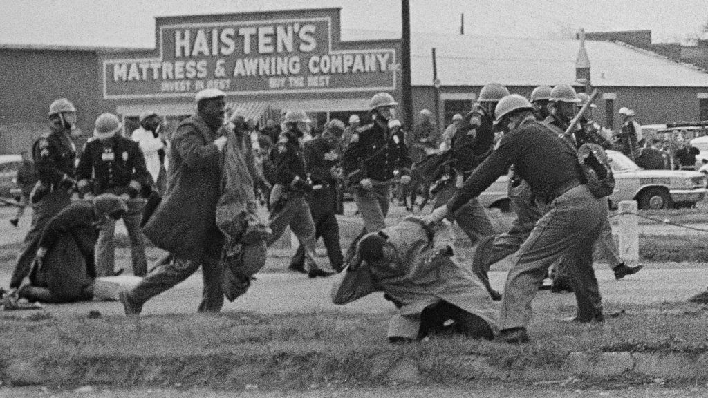 State troopers swing billy clubs at protesters, including John Lewis in the foreground, at a civil rights voting march in Selma, Ala., on March 7, 1965, that became known as Bloody Sunday. CREDIT: AP