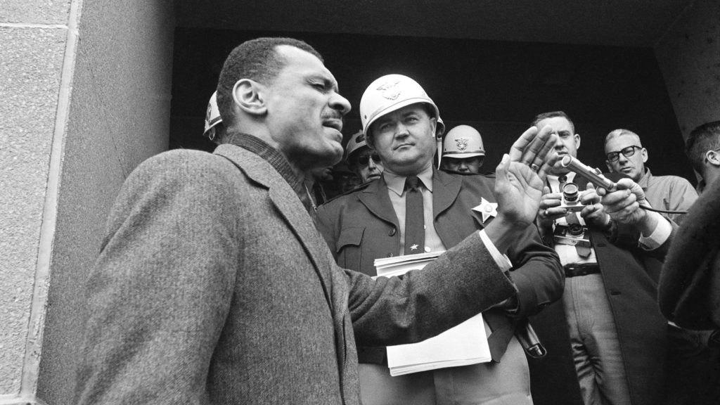 C.T. Vivian, leads a prayer on the steps of the the courthouse in Selma, Ala., in February 1965, after Sheriff Jim Clark (in a white helmet) stopped him at the door with a court order. During another confrontation on the same steps just days later, the segregationist sheriff punched Vivian to the ground — and Vivian stood back up to continue his argument. CREDIT: Horace Cort/AP