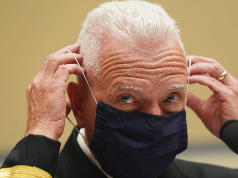 Adm. Brett Giroir, assistant secretary for health in the Department of Health and Human Services, adjusts his face mask while testifying this month before a House subcommittee on the coronavirus crisis. CREDIT: Kevin Lamarque/Pool/Getty Images