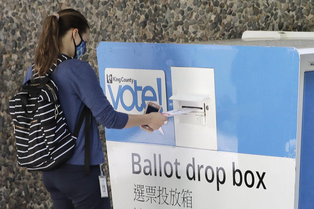A person drops off a ballot for Washington state's primary election, Tuesday, Aug. 4, 2020, at a collection box at the King County Administration Building in Seattle. CREDIT: Ted S. Warren/AP