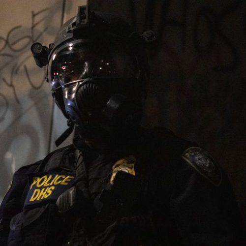 A Department of Homeland Security officer patrols the Mark O. Hatfield federal courthouse in Portland, Ore., July 25, 2020. CREDIT: Bradley W. Parks/OPB
