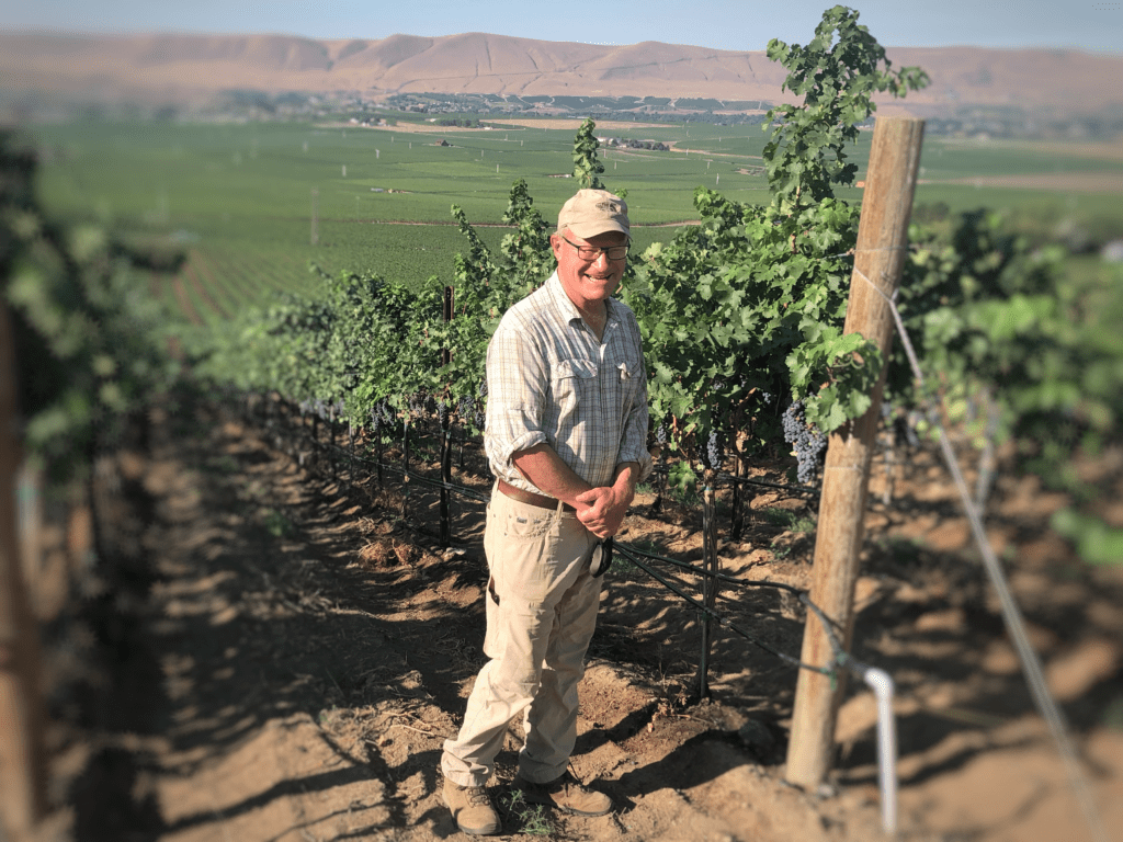 Dick Boushey inspects the drip irrigation at Longwinds Vineyard on Red Mountain in southeast Washington. CREDIT: Anna King/N3