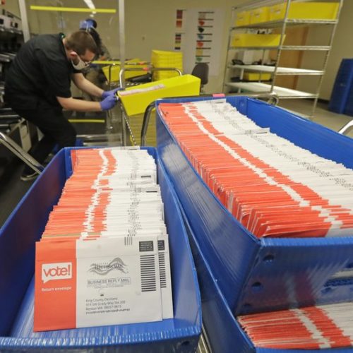 In this Aug. 5, 2020, vote-by-mail ballots are shown in sorting trays at the King County Elections headquarters in Renton, Wash. As of Tuesday, Aug. 11, 2020, nearly 53% of the ballots have been processed, with just over 53,000 remaining. CREDIT: Ted S. Warren/AP