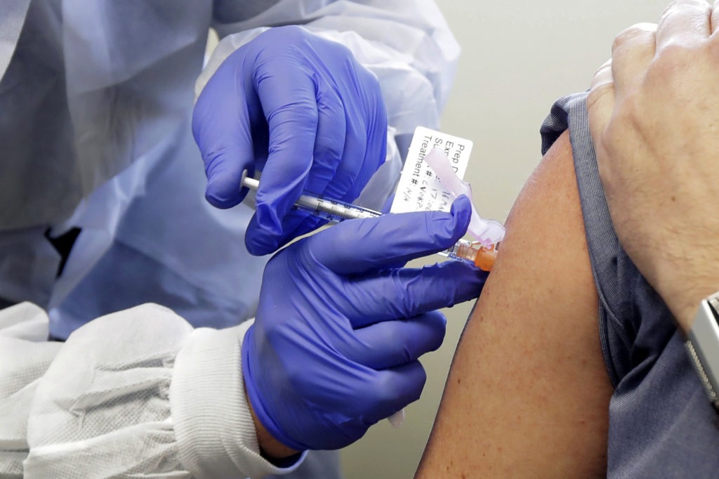 The second patient in a first-stage study of a potential vaccine for COVID-19 receives a shot in in March at the Kaiser Permanente Washington Health Research Institute in Seattle. CREDIT: Ted S. Warren/AP