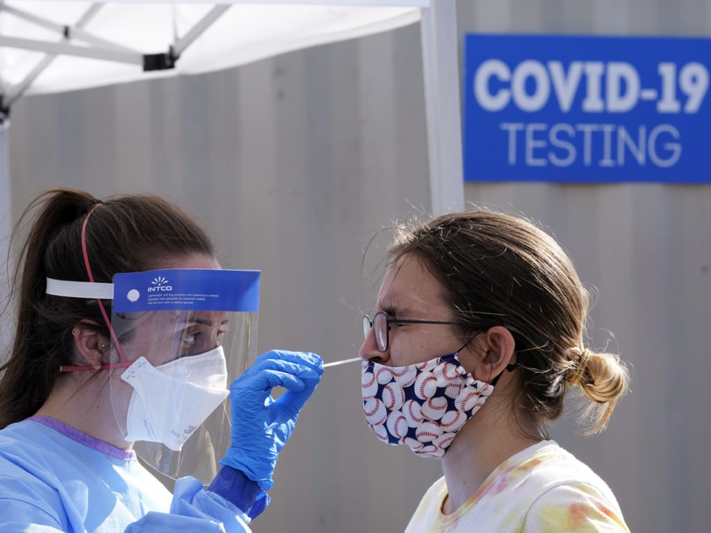 People stand in line for free COVID-19 testing at Bellevue Hospital in New York earlier this month. The daily number of new coronavirus cases reported in the U.S. has remained stubbornly high. CREDIT: Bryan R. Smith/AFP via Getty Images